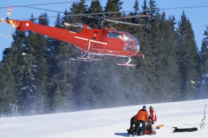 red rescue helicopter arriving after a ski accident in the Swiss Alps; Lech, Switzerland