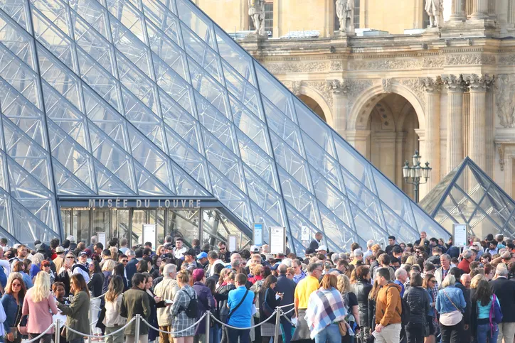 People queue at Louvre museum, Paris France.