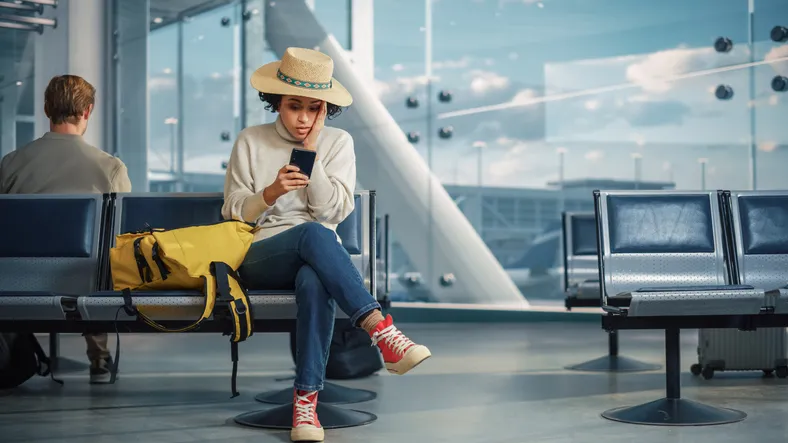 Upset, Sad, and Dissappointed Person Sitting in a Boarding Lounge of Airline Hub.