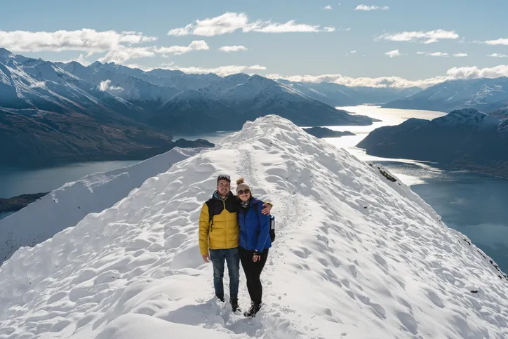 Couple looking at camera at Roy's Peak Lookout. Wanaka, Otago Region, New Zealand