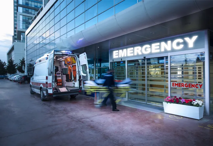 Paramedics taking patient on hospital stretcher from ambulance