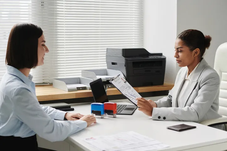 Young woman having interview with specialist in visa center to get visa