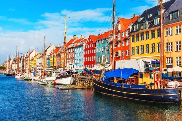 Scenic summer view of Nyhavn pier with color buildings, ships, yachts and other boats in the Old Town of Copenhagen, Denmark