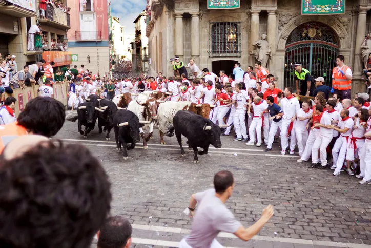 Unidentified men run from bulls in street Estafeta during San Fermin festival in Pamplona.