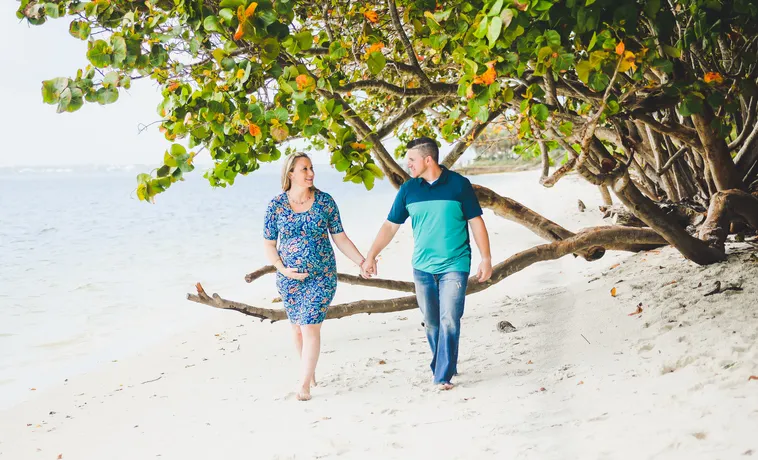 Adorable couple holding hands walk on a scenic beautiful beach