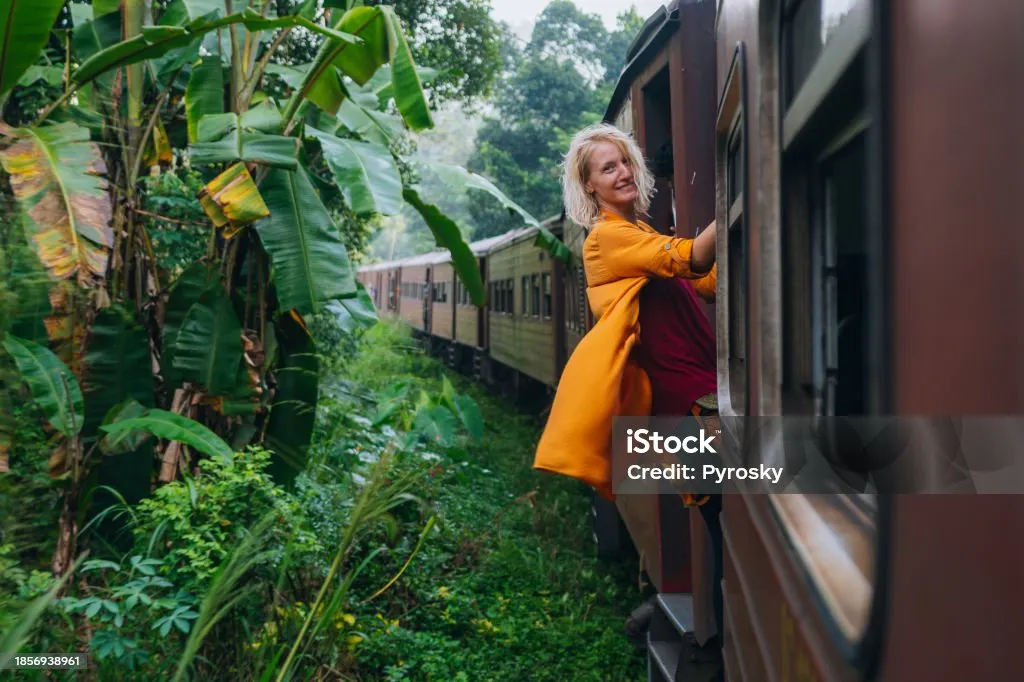 A woman enjoys a train ride in Sri Lanka